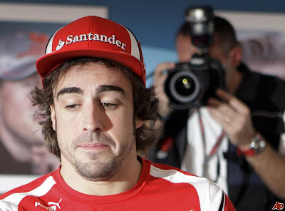 уставший Фернандо Алонсо и фотограф позади на автограф-сессии Гран-при Абу-Даби 2011