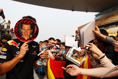 Марк Уэббер закрывается кругом Михаэля Шумахера на раздаче автографов для болельщиков Шанхая на Гран-при Китая 2011
