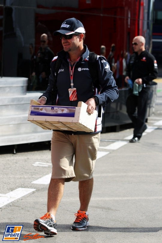 Рубенс Баррикелло несет ящик по паддоку на Гран-при Испании 2011
