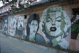 portraits of Michael Jackson and Marilyn Monroe on a brick wall