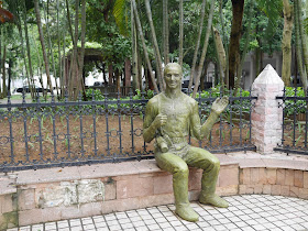 statue of Western-looking man with a camera and wearing a shirt with the words "湛江 Very Good"