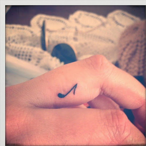 small music note tattoo on finger