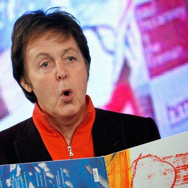 Musician Paul McCartney holds a copy of his album for photographers at a signing session at a music store, in central London.