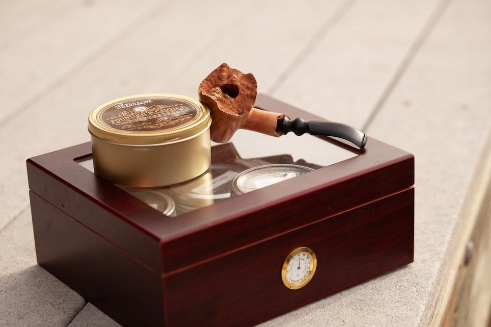 tobacco pipe and herb grinder on brown box