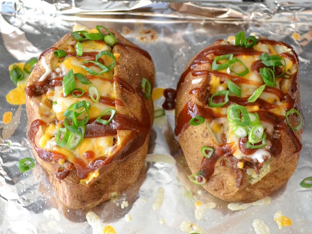 green onion and bbq sauce on top of cooked potatoes 