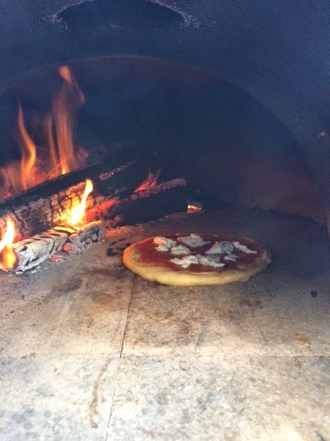 The inside of a wood burning pizza oven with pizza in full view.  Photo courtesy of Dr. K.