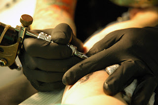 Tattoos in Mexico, tattoo artist in the middle of the process of injecting ink