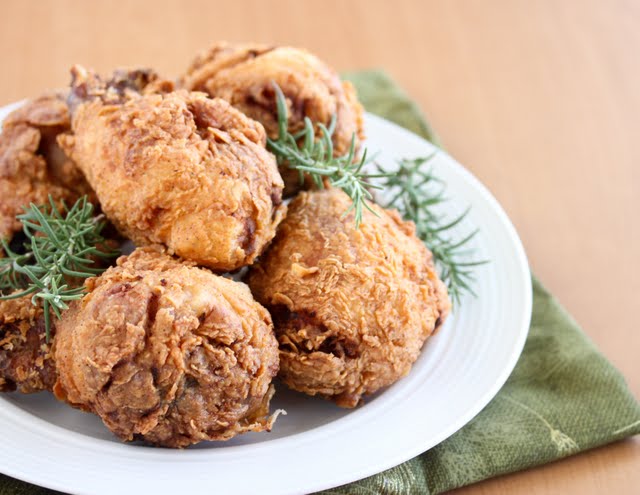 photo of a pile of fried chicken on a plate garnished with fresh rosemary