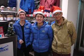 Three young men wearing Santa hats in Putian, China