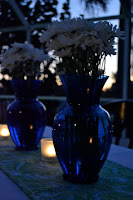 The blue vases compliment the white daises. 
