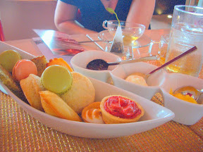 Wave Restaurants accompaniments with tea: Sweets of Macaroons- sea salt and caramel, lemon, chocolate and berry , Scones- butter and orange-vanilla, Madeleine- vanilla and orange zest , Market fresh fruit tarts , Tea cakes- lemon-poppy seed and chocolate chip with Devonshire cream, lemon curd and strawberry jam