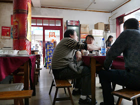 three people sitting on benches eating lunch in Changsha, China