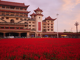  field of red flowers in front if Chinese style gate building