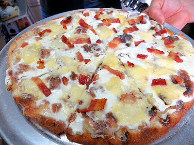 Pulehu Pizza grilled pizza Alsatian Flamee with a sour cream base, onion and bacon, and here St Nectaire Cheese