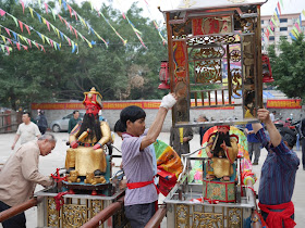people taking the enclosures off god figures in Maoming, China