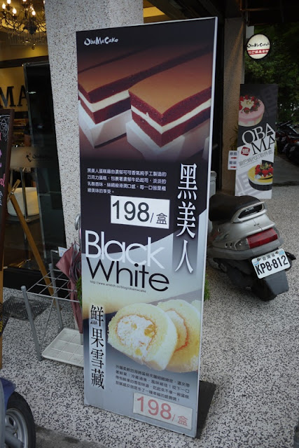 sign with images of a black layered cake and a white cake roll