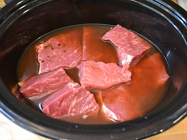 beef broth poured over roast in slow cooker 