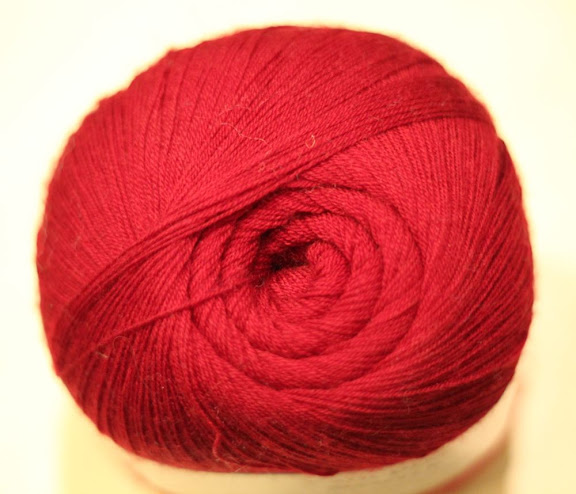 a skein of fine red yard wound so the end looks like a fractal spiral