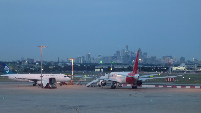 Aircraft and the Sydney CBD at dusk