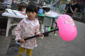little girl holding a large inflatable hammer in Zhongwei, Ningxia, China
