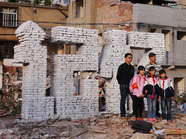 two artists and 3 young girls posing for a photo in front of the sculpture of "记忆".