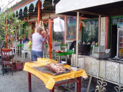 シルクロード旅行記・新疆ウイグル|クチャ農貿市場、店頭で巨大な羊肉をさばく食堂のオヤジ