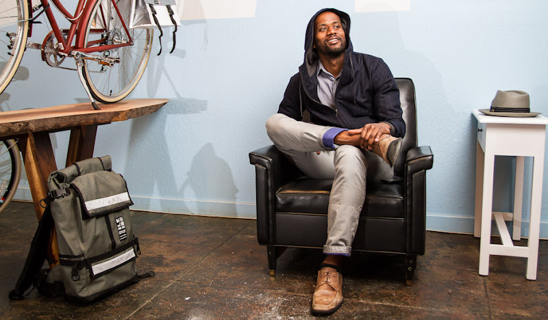 Navy Exec Hoodie sits in Leather Chair