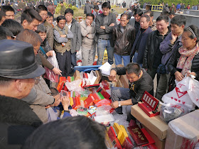 crowd surrounding a seller at an outdoor antique market in Changsha, China