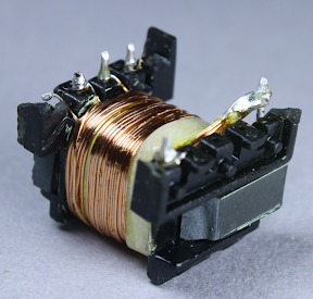 The first half of the primary winding in the flyback transformer. Note the 3mm white boundary tape at the right that keeps the winding away from the edge.