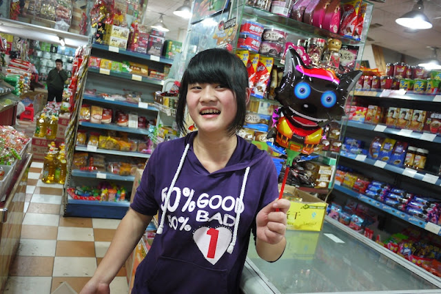 young worker at a store holding a cat balloon in Changsha, China