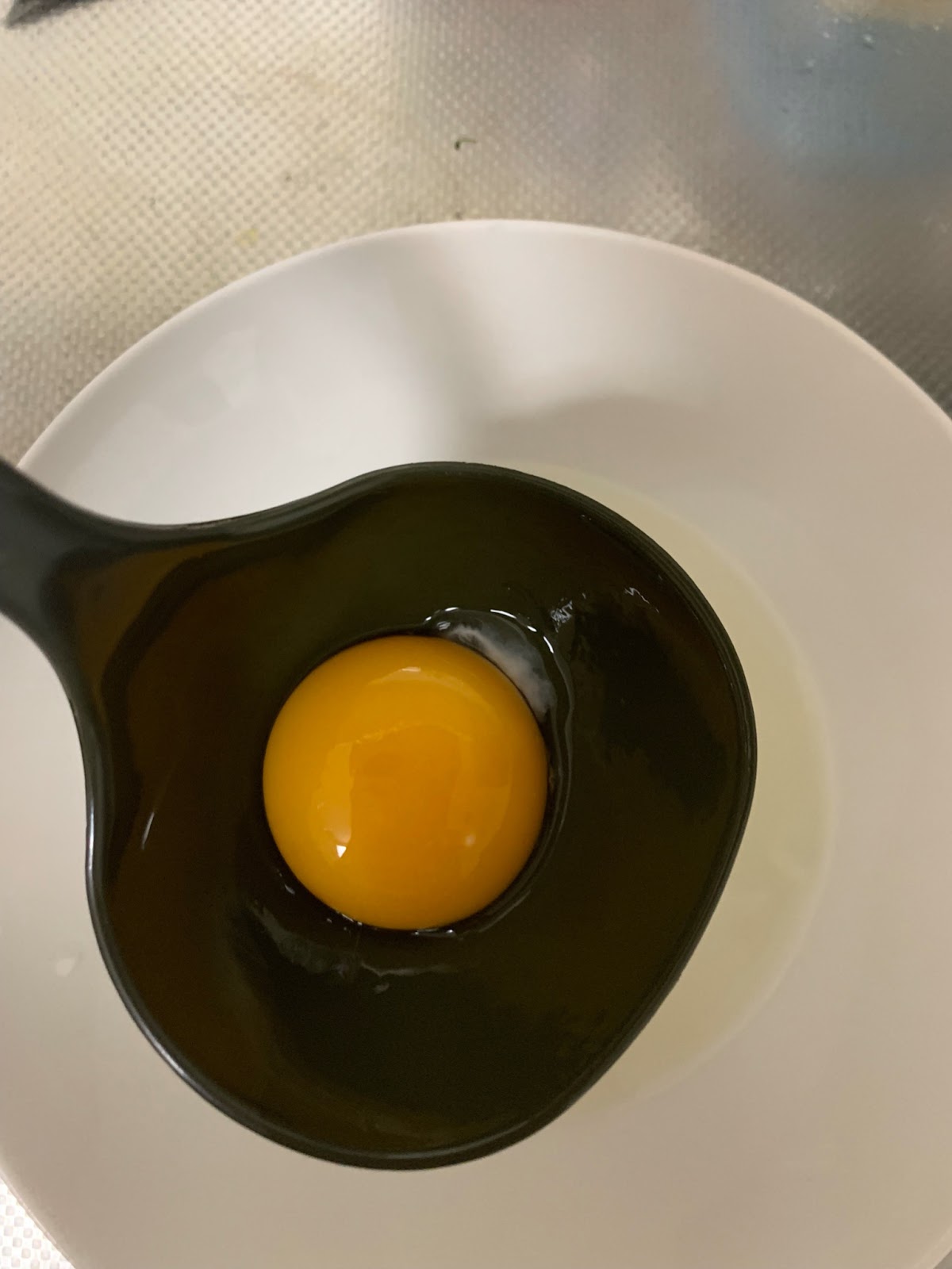 3．すると卵がゆっくりとおたまの中に入ってきて黄身と白身に分けられます。