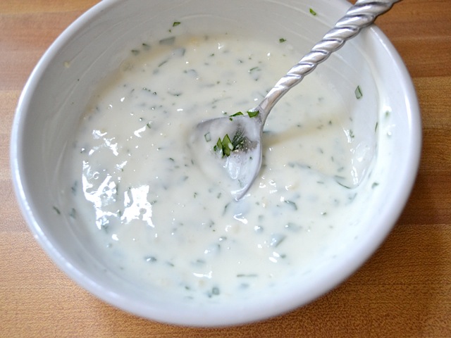 garlic yogurt sauce in bowl with spoon 