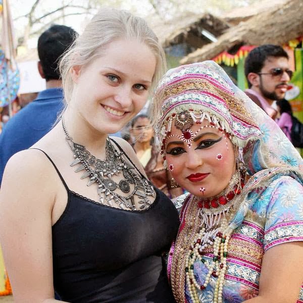 A foreign tourist poses for photograph with a Braj artist during 28th Surajkund International Crafts Mela in Faridabad.