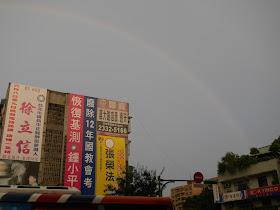 rainbow arching over buildings in Taipei