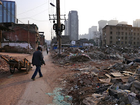man with a two-wheeled wooden wheelbarrow collecting scraps from the demolished buildings at Beizheng Street in Changsha