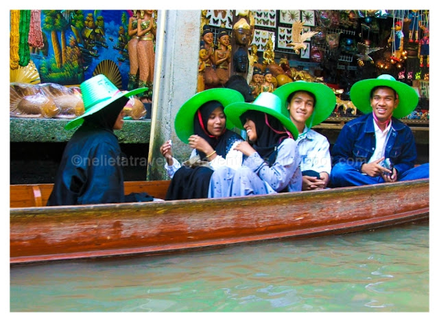 A group of people in the boat as we passed them. They were all wearing bright green hats and were enjoying the time in the floating market of Damnoen Saduak, Thailand.