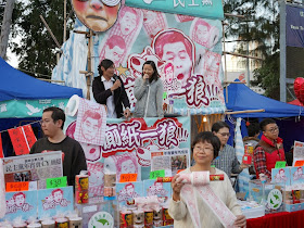 Woman displaying toilet paper with Hong Kong Chief Executive Leung Chun-ying's face 