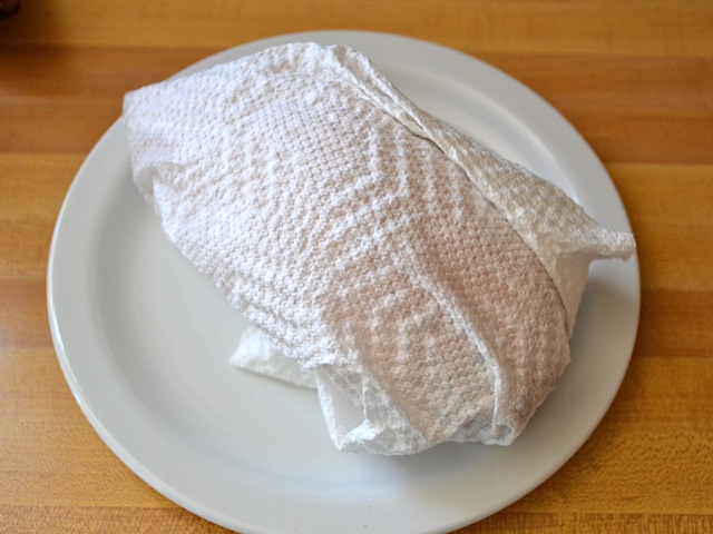 one sweet potato wrapped in paper towel ready to microwave 