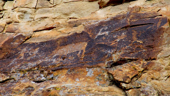 On each side of this petroglyph panel, there appear to be human figures pointing arrows at each other