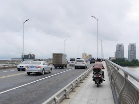 man riding a motorbike on a bridge's pedestrian sidewalk