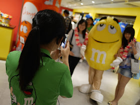 M&M's World staff taking a photo of customers with an M&M's character in Shanghai