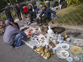 seller smoking from a metal pipe at an outdoor antique market in Changsha, China