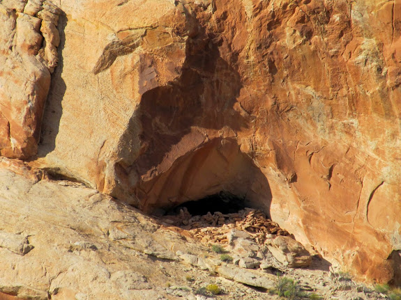 Cave with rocks stacked in the entrance and a soot-stained ceiling