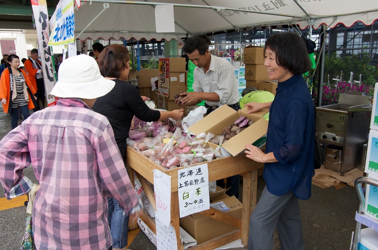 お客様にじゃがいもの種類の説明をする高井さん