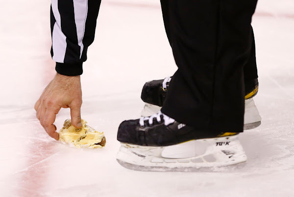 Ref picks up hot dog that was thrown onto the ice during shootout