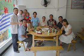 10 people around a wooden table with benches.
