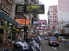 advertisements hanging over a sidewalk and street in Mongkok, Hong Kong