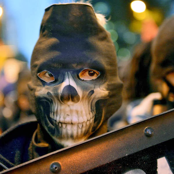 A demonstrator with his face covered hold as shield during a march in support of teachers on strike in Rio de Janeiro, Brazil.