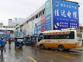 bus parked on the side of a road next to a shopping center in Changde