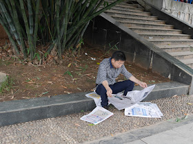 man reading a newspaper in Hengyang, Hunan, China